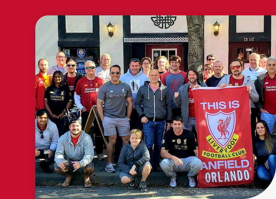 Large group of Central Florida Liverpool FC supporters holding flag